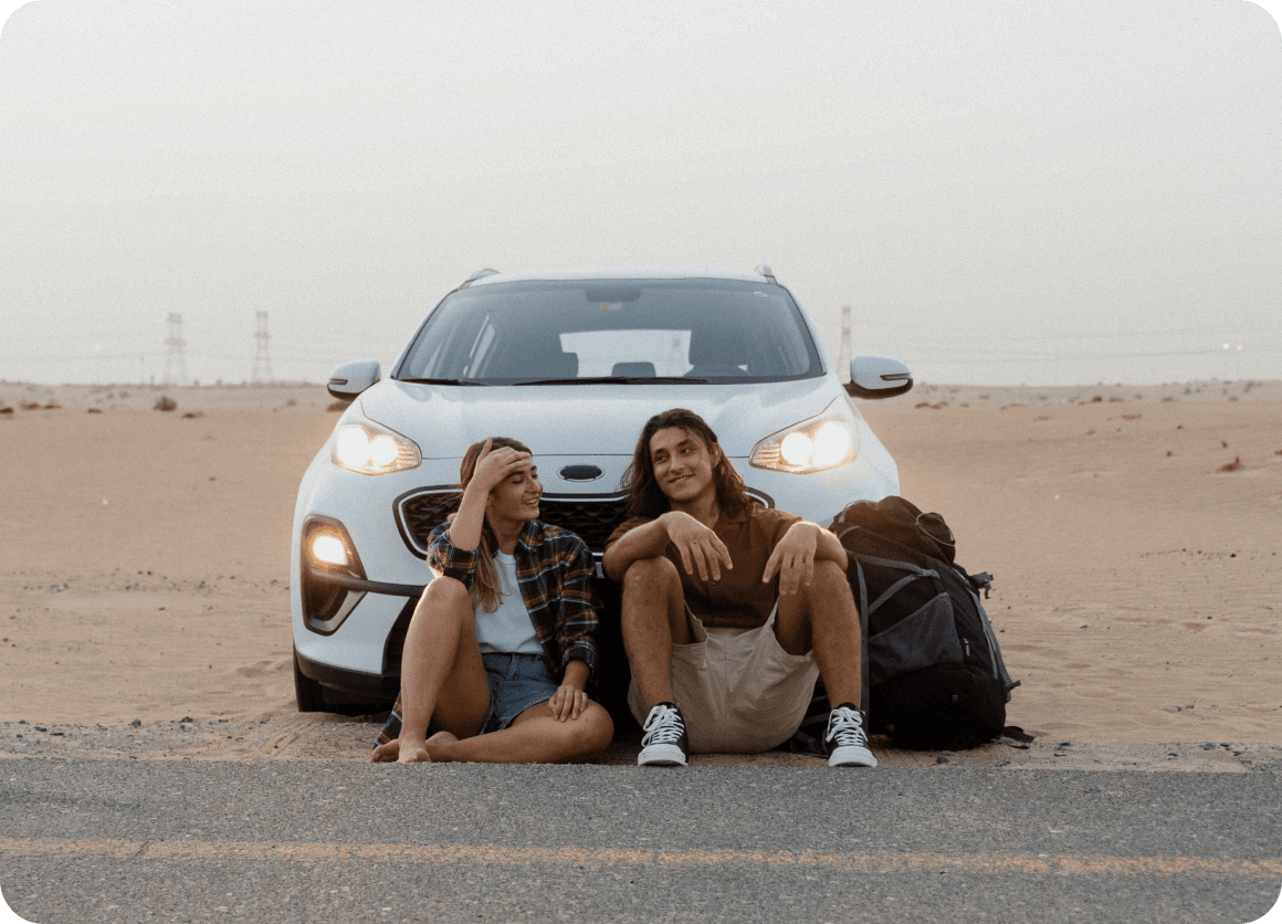 Pareja sentada frente al coche